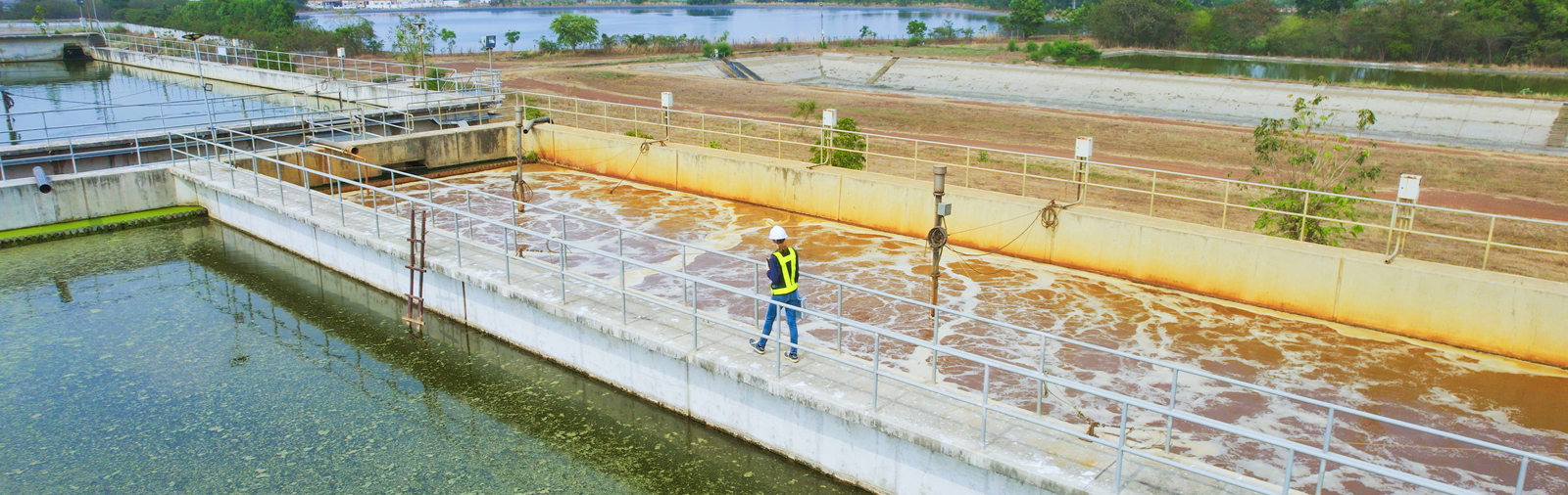 Aerial view of wastewater treatment facility with an engineer working on-site.