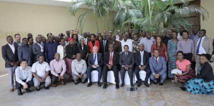 A large group of attendees posing for a group photo in an indoor venue.