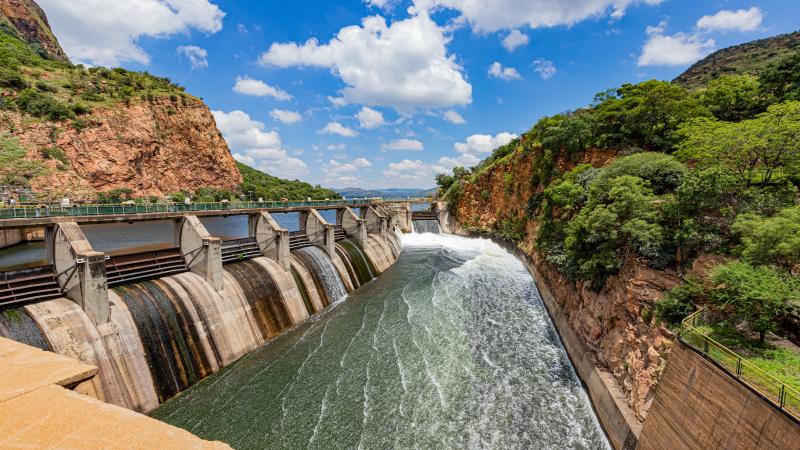 Dam runoff water in Hartebeespoort, South Africa, with surrounding structures.